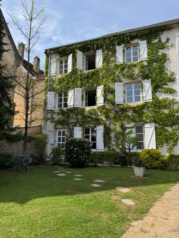 an ivy covered building with a yard at Villa Saint-Georges in Vesoul