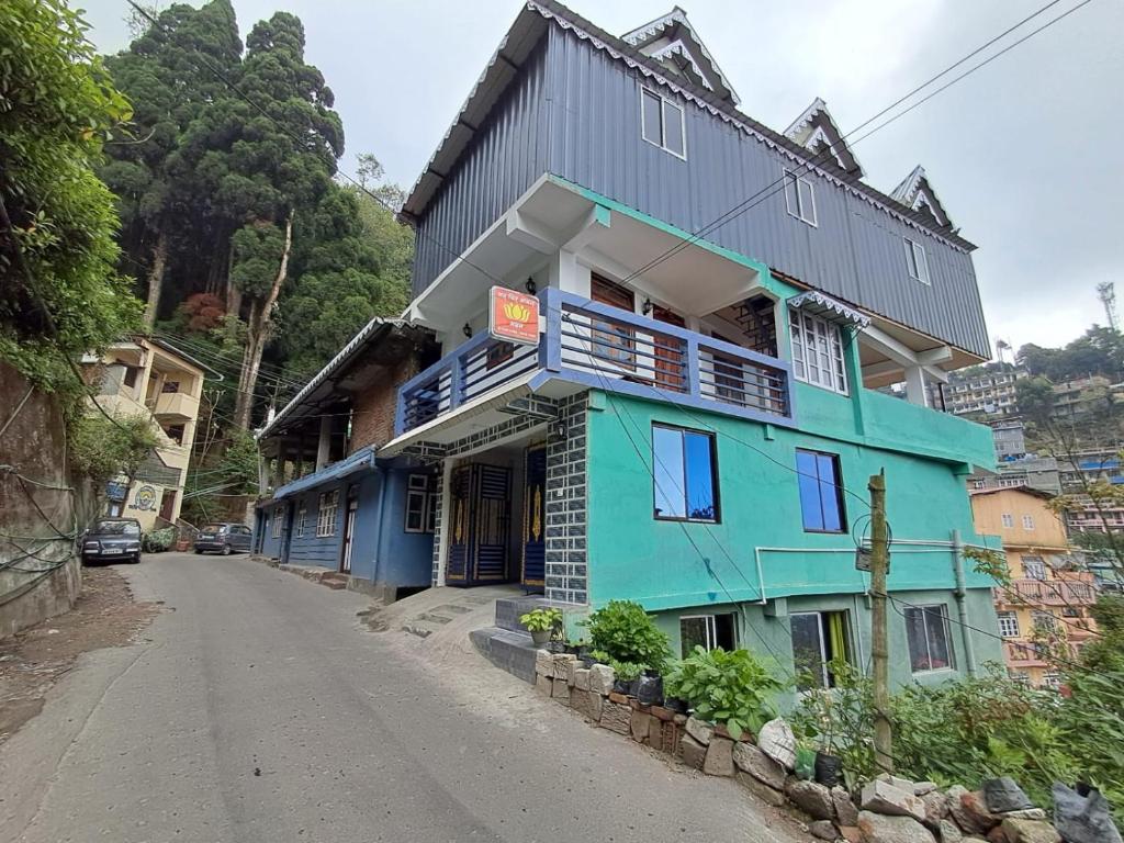 Un edificio colorido al costado de una carretera. en Sat Chit Ananda bhavan, en Darjeeling