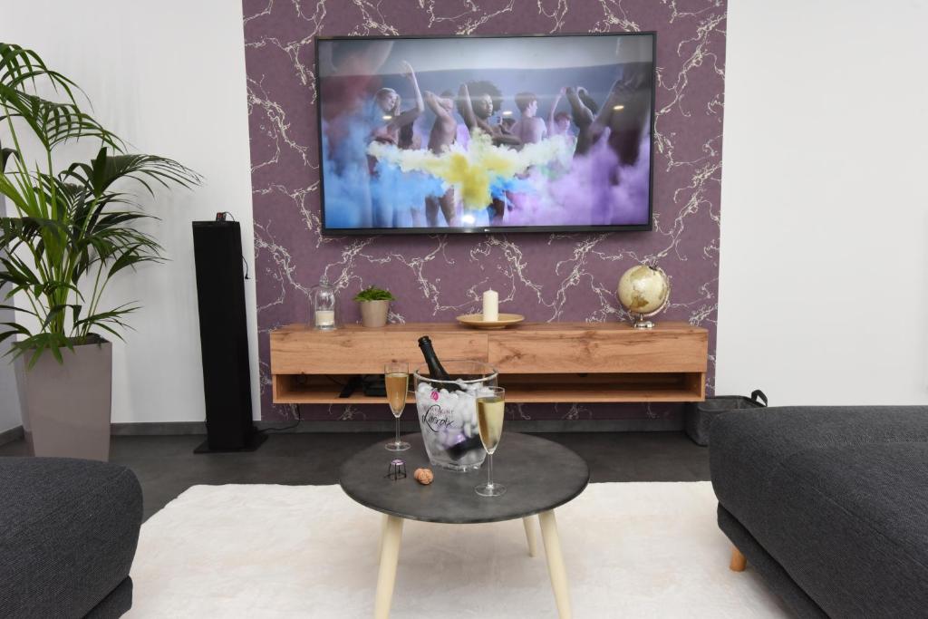 a living room with a flat screen tv on a wall at Le Ray's Inn in Épernay