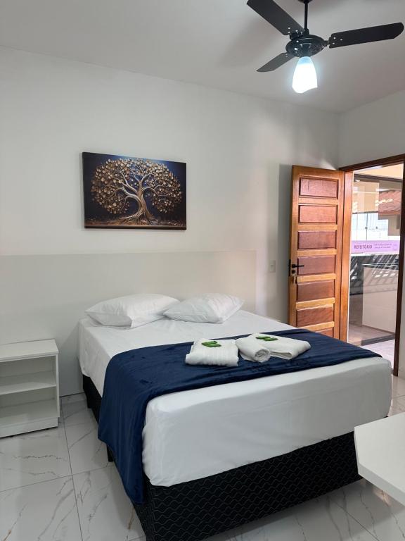 Pousada Recanto das Bromélias في ساو ثومي داس ليتراس: غرفة نوم بها سرير عليه منشفتان