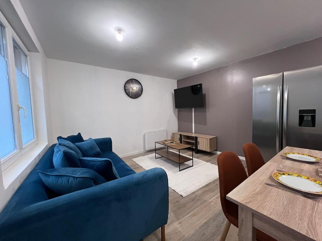 ein Wohnzimmer mit einem blauen Sofa und einem Tisch in der Unterkunft Maison Moderna-8 personnes-WiFi-Centre ville in Fontenay-le-Comte
