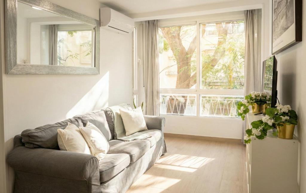 ein Wohnzimmer mit einer Couch und einem Fenster in der Unterkunft 3 Double Beds - Great Area, Perfect for Families in Sevilla