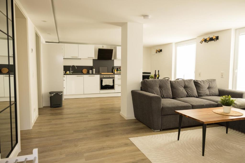 un salon avec un canapé et une table dans l'établissement Moderne und gemütliche Ferienwohnung in Holzbach, à Holzbach