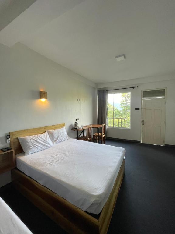 sypialnia z łóżkiem, stołem i oknem w obiekcie Crystal Resort w mieście Badulla