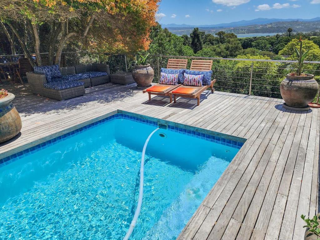 una piscina con un tubo collegato a un ponte di legno di Villa Candle Berry - Tranquil Lagoon Retreat a Brenton-on-Sea