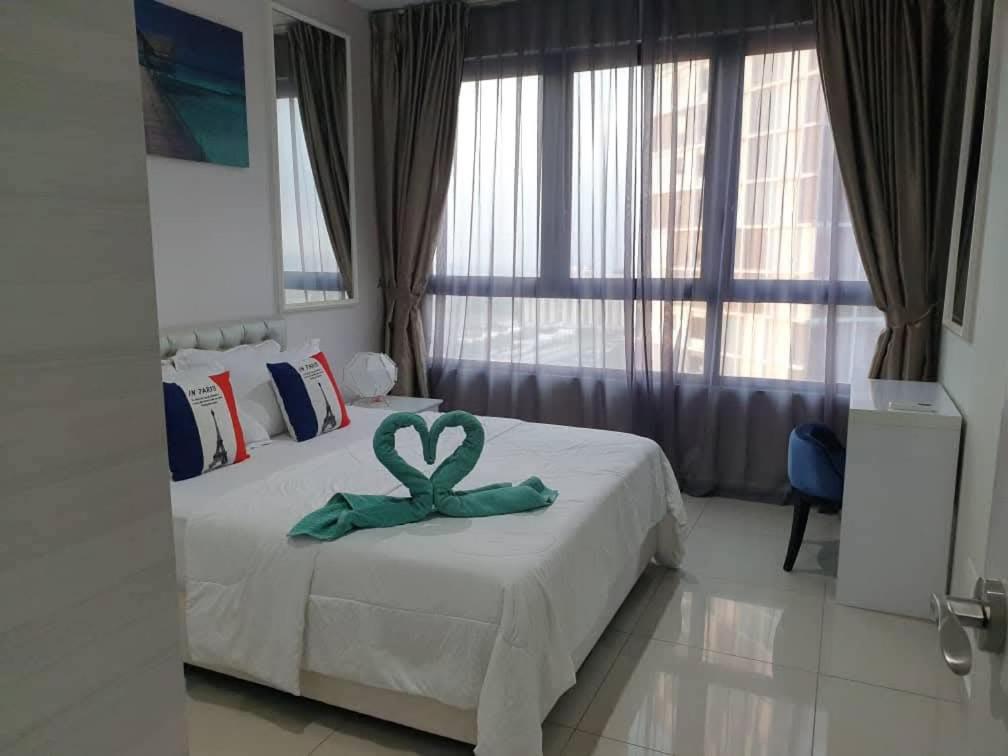 um quarto com uma cama com uma fita verde. em Dz Studio and Suite Parisien Tower i-City em Shah Alam