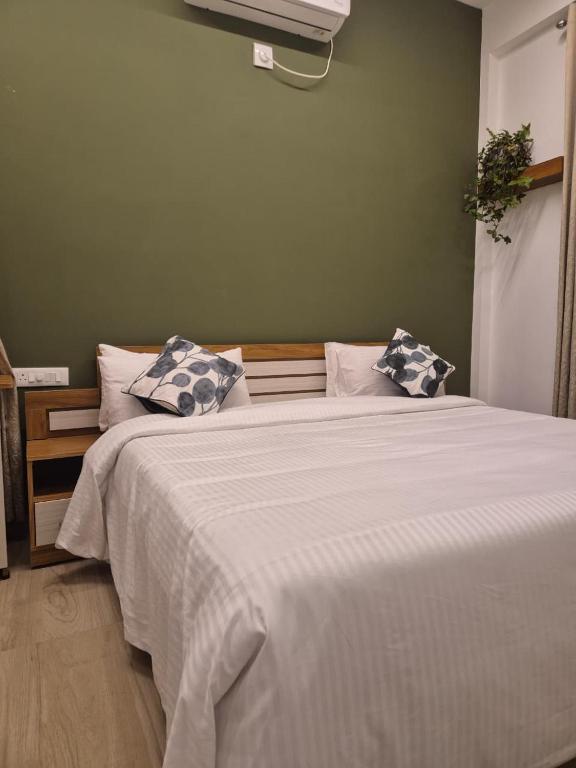 Un dormitorio con una gran cama blanca con dos almohadas. en Willow The Villas, en Mananthavady