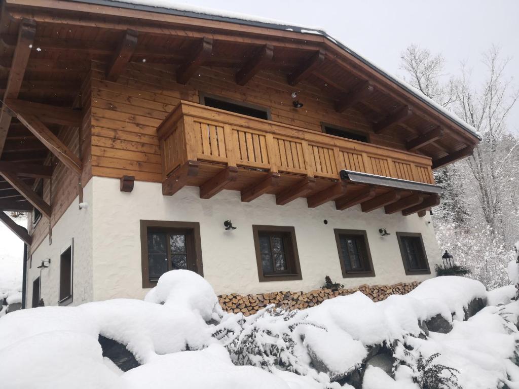 a log cabin with a balcony in the snow at ChaTále - Chalúpky Tále in Tale