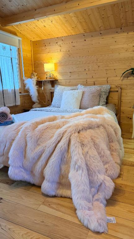 a bedroom with a large bed with a furry blanket at Chalet avec salle d'eau in Chavagne