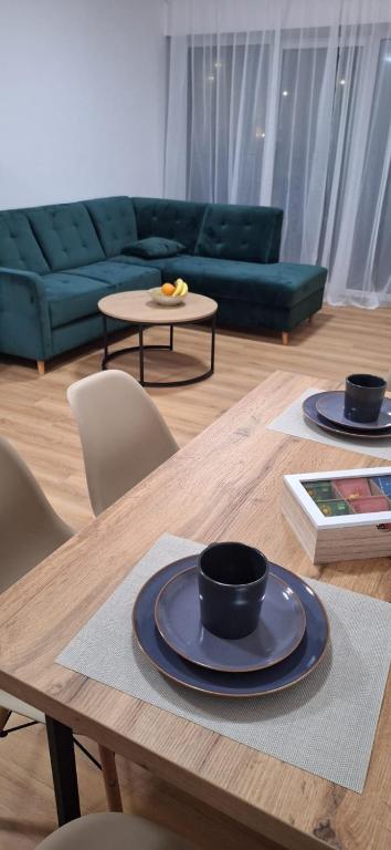 a wooden table with two black cups on top of it at Apartament Sobieskiego 2, bezpłatny parking in Świebodzin