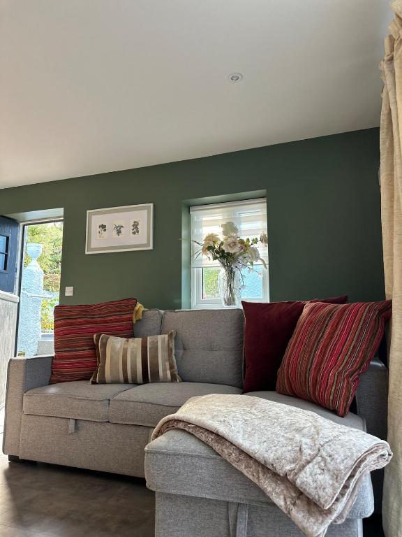 a couch in a living room with a green wall at The riverside place in Newry