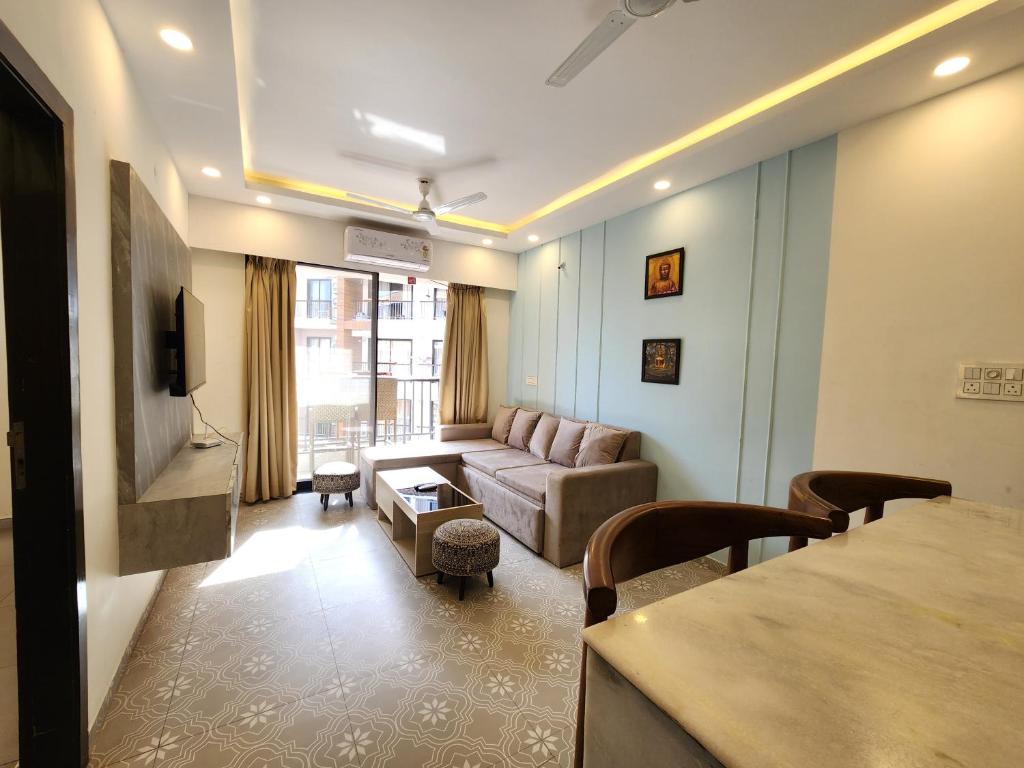 una sala de estar con un sofá y una mesa en Calm 1BHK Modern Apartment in Candolim with Pool, Balcony & Modern Decor, en Candolim