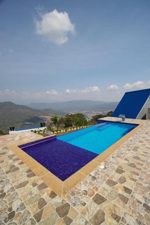 a swimming pool with a view of a house at Casa guardían del bosque in San Gil