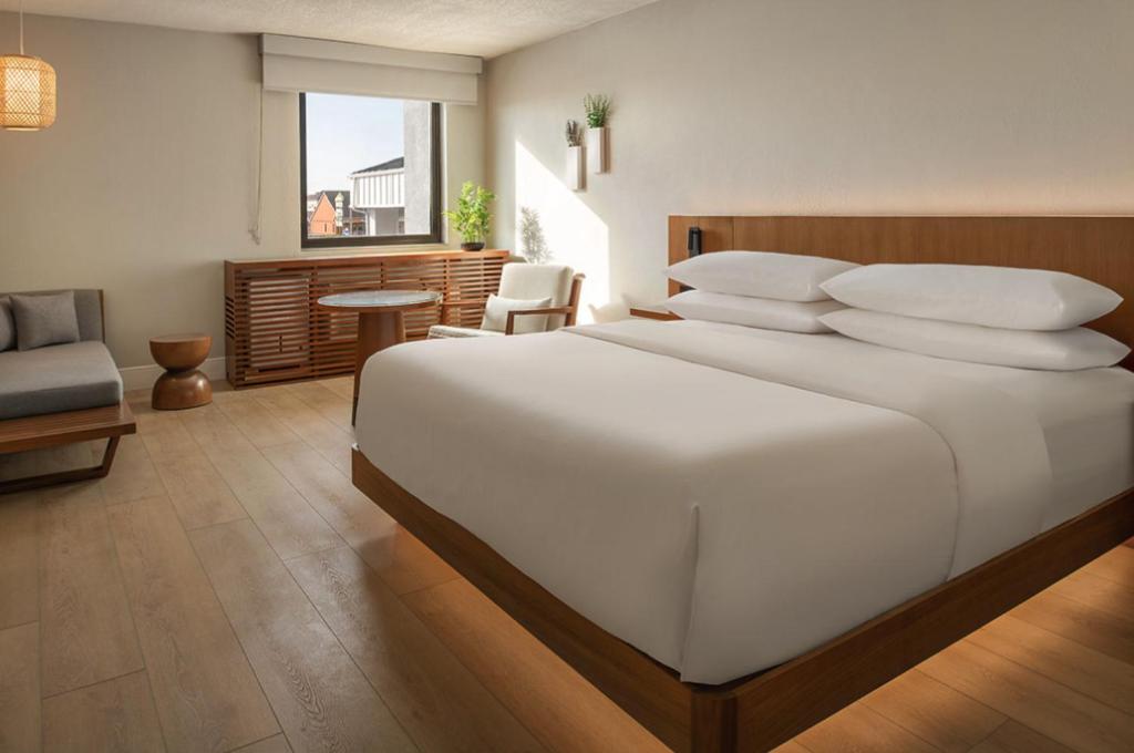 韦恩堡The Amaya - 21 and older only的卧室里有一张白色的大床和一把椅子