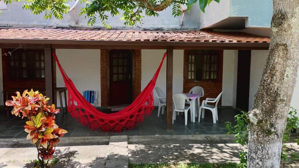 a house with a red hammock on the porch at Casa do sossego - conforto, praia, piscina in Maricá