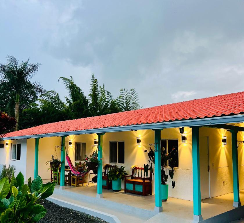 ein Haus mit einem roten Dach und einer Terrasse in der Unterkunft Finca Bella Village Para Amantes del Entorno Rural in Jiguales