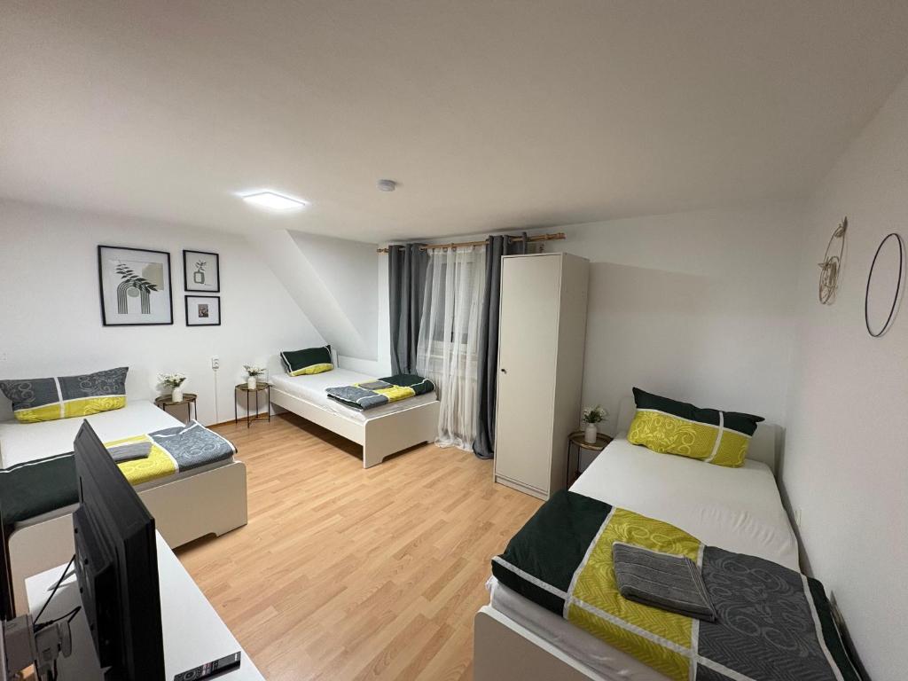 une chambre avec deux lits et un salon dans l'établissement Monteurzimmer, Monteurunterkunft in 20 km von Hanau und 35 km von Frankfurt am main, à Florstadt