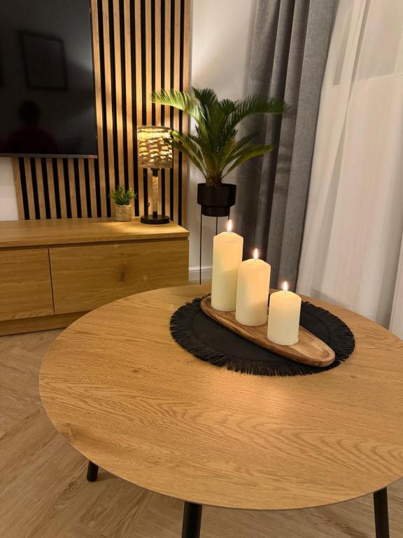 a table with three candles on top of it at W275 Apartment in Pruszków