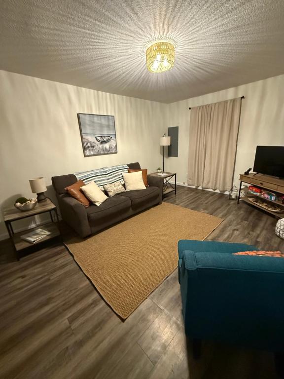 un soggiorno con un divano e un tappeto di Little Blue a Van Buren