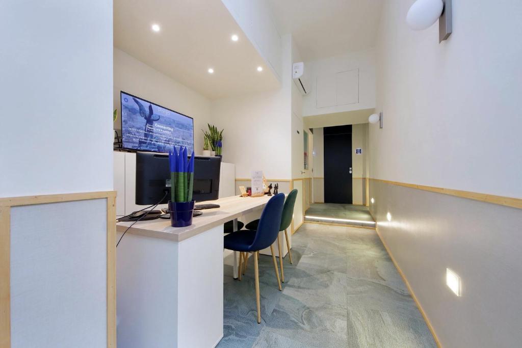 an office with a desk with a computer and chairs at Proja Housing Romagnosi20 in Rome