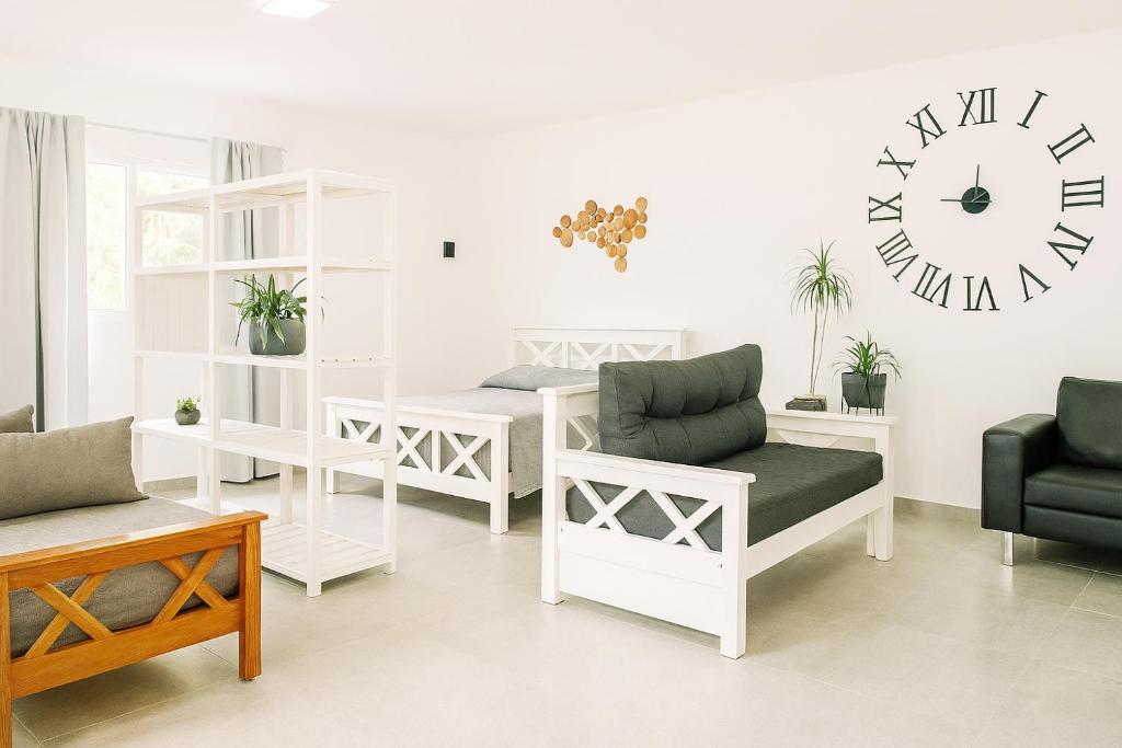 un soggiorno con mobili bianchi e un orologio a parete di Departamento LUNA NUEVA a Santa Clara del Mar