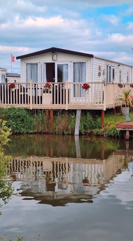 a mobile home on a dock next to a body of water at Carnaby Rosedale in Crowle