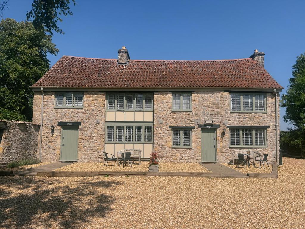 une vieille maison en pierre avec des tables et des chaises devant dans l'établissement The Potting Shed, à Chepstow