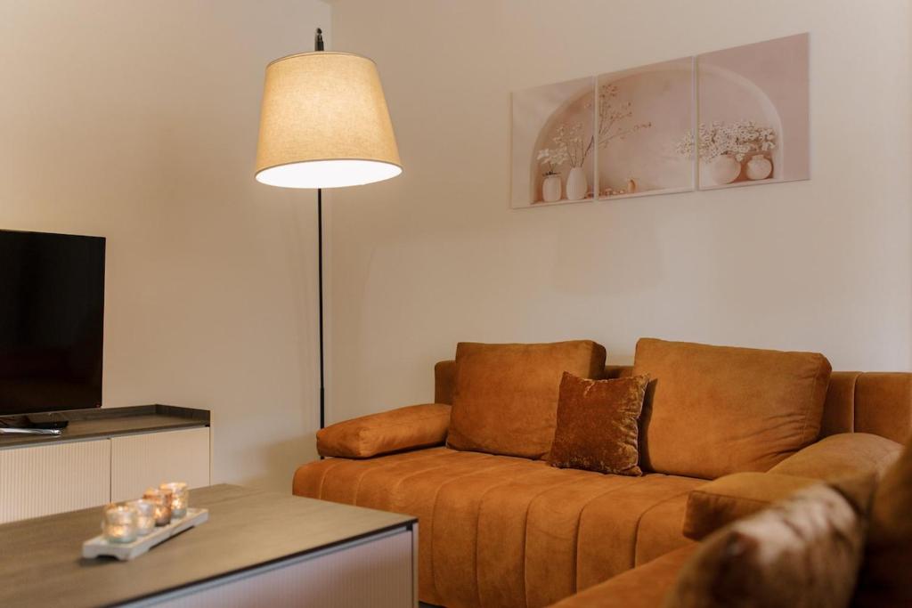 ein Wohnzimmer mit einer Couch und einer Lampe in der Unterkunft Spacious 1BR Designer Apartment in Sloboština in Zagreb