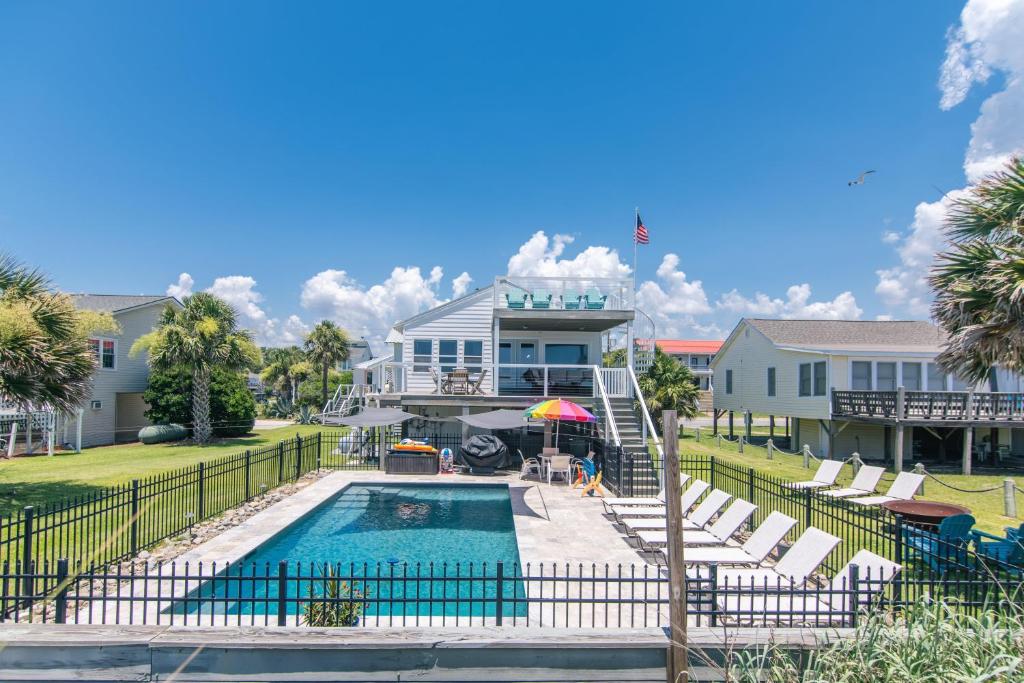 una casa con piscina delante de una casa en Marysol, en Edisto Beach