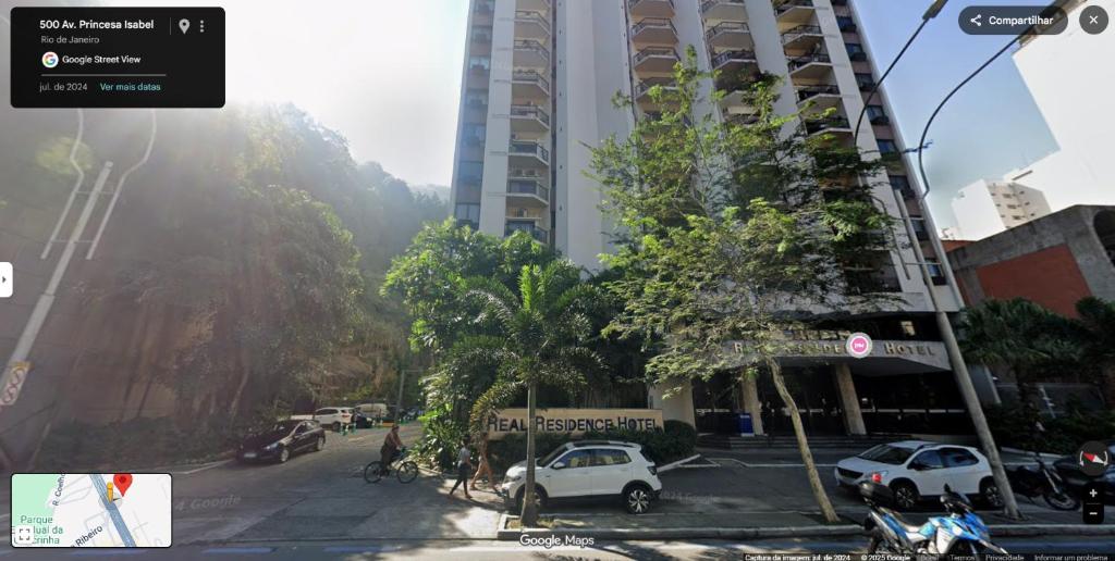 a city street with cars parked in front of a tall building at Suíte Aconchegante em Copacabana - Piscina, Wi-fi e perto da praia in Rio de Janeiro