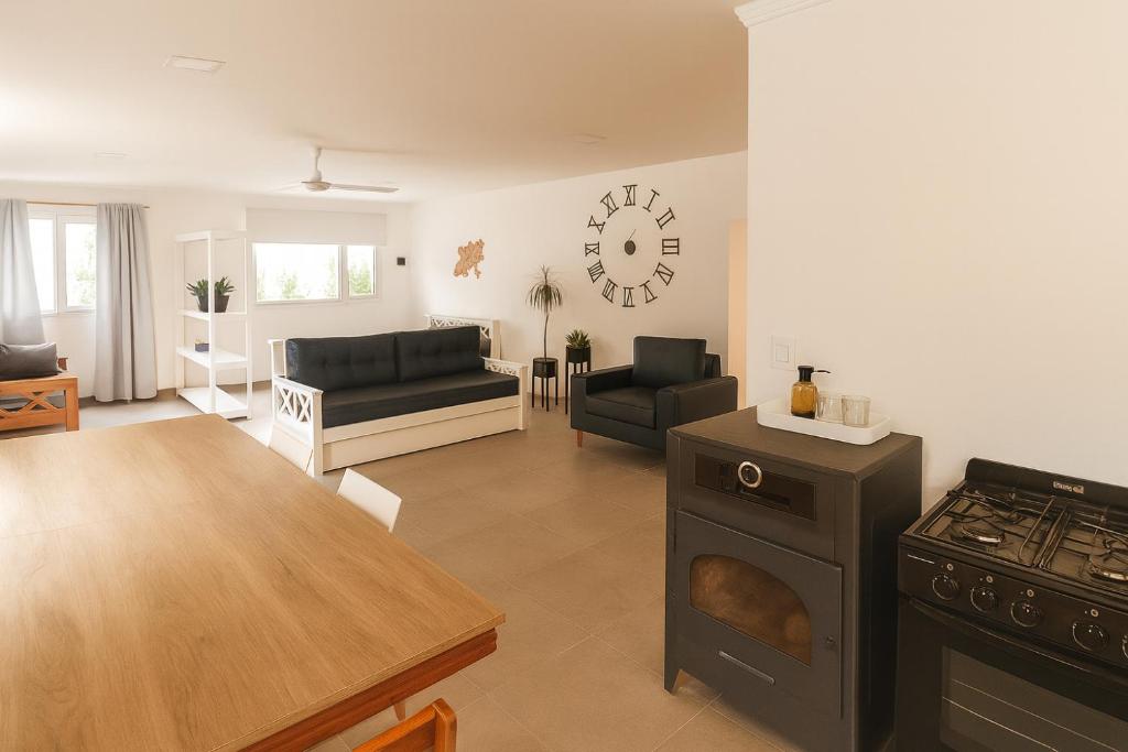 Departamento LUNA NUEVA في سانتا كلارا ديل مار: مطبخ وغرفة معيشة مع موقد وطاولة