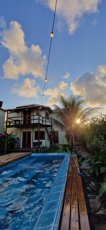 a villa with a swimming pool in front of a house at Pousada Vila Cacau in Serra Grande