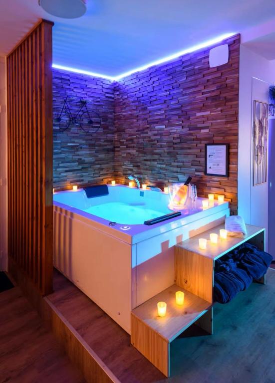 a hot tub in a room with a brick wall at Evasion à deux - Spa privatif in Beaugency