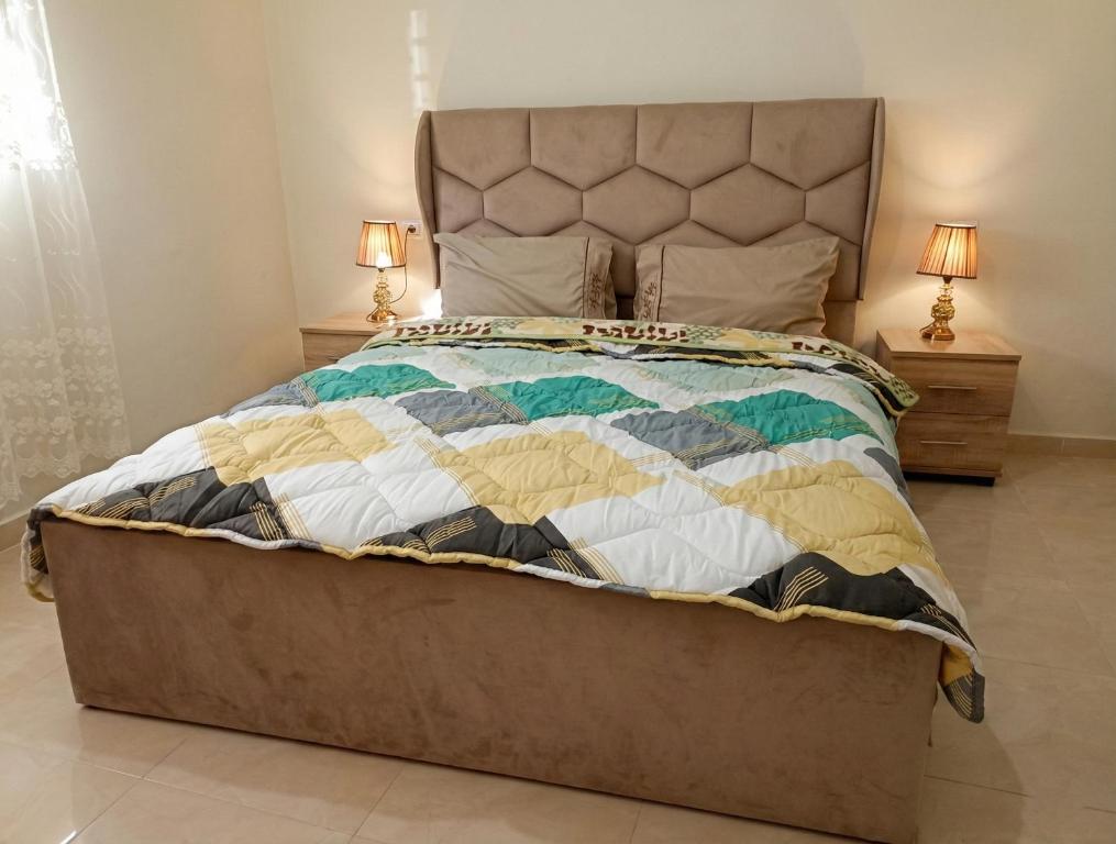 Una cama con edredón en un dormitorio en Appartement in ground floor in Al houceima, en Alhucemas