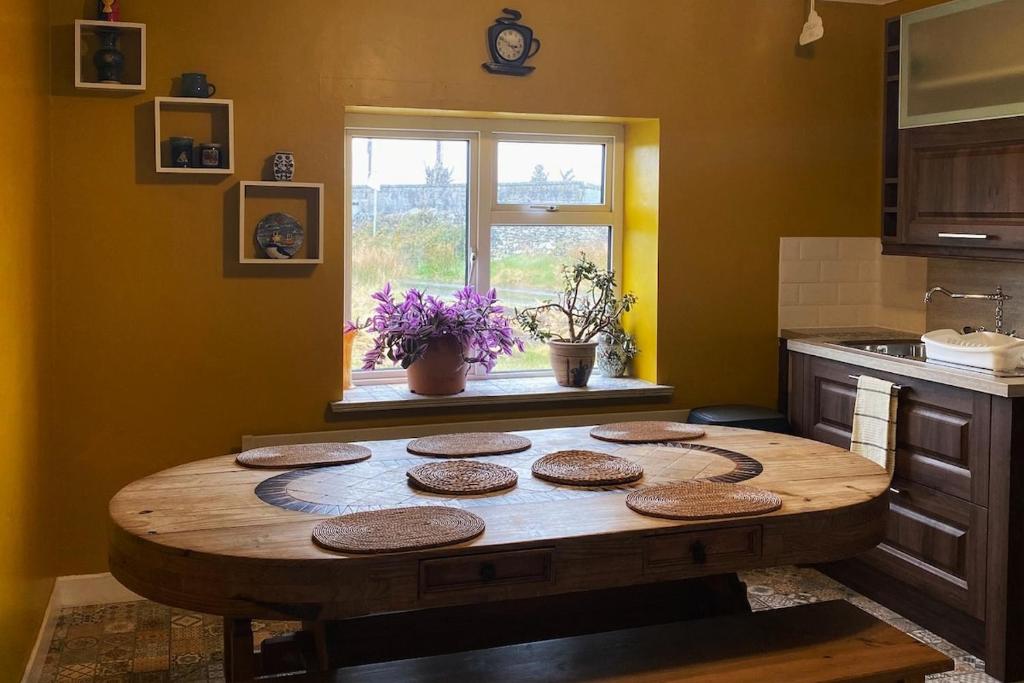 米尔敦马尔贝Station House Accommodation的带窗户的厨房内的木桌