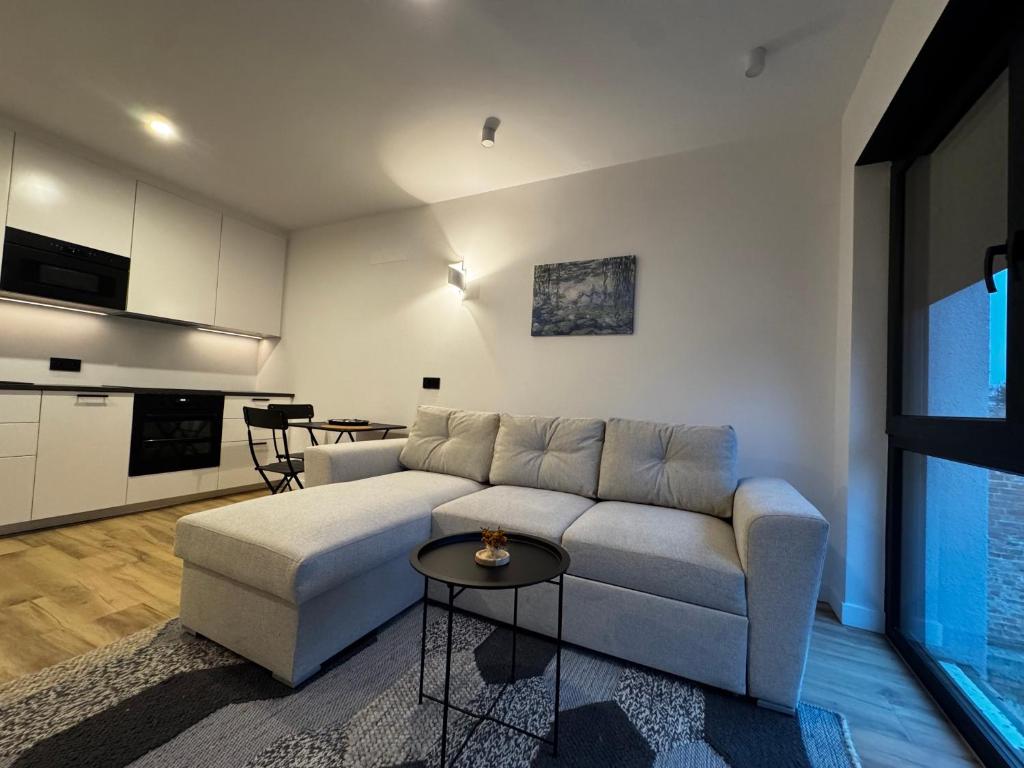 una sala de estar con un sofá y una mesa en Apartamenty Forestlive, en Międzychód