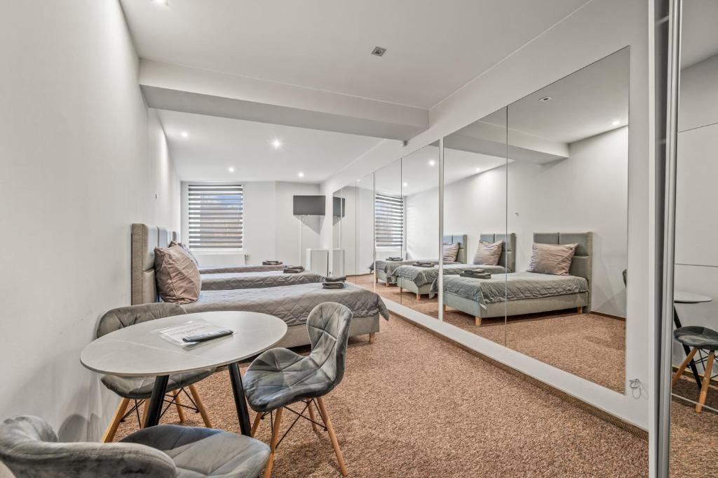 een kamer met bedden en een tafel en stoelen bij Apartamenty Centrum in Rybnik