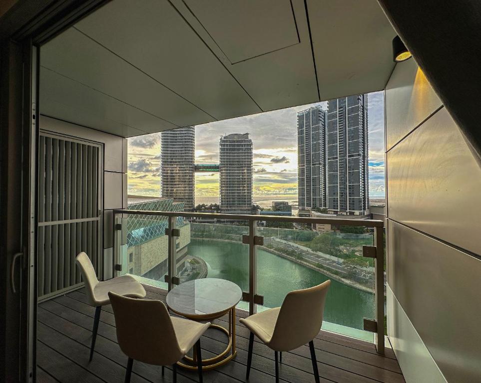 einen Balkon mit einem Tisch und Stühlen sowie Stadtblick in der Unterkunft Seaview stay at Cinnamon Life Residence - City of Dreams in Colombo