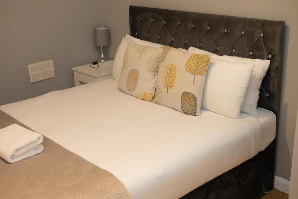 a bedroom with a large bed with pillows at King Edward 3 bed house ideal for contractors in Darlaston