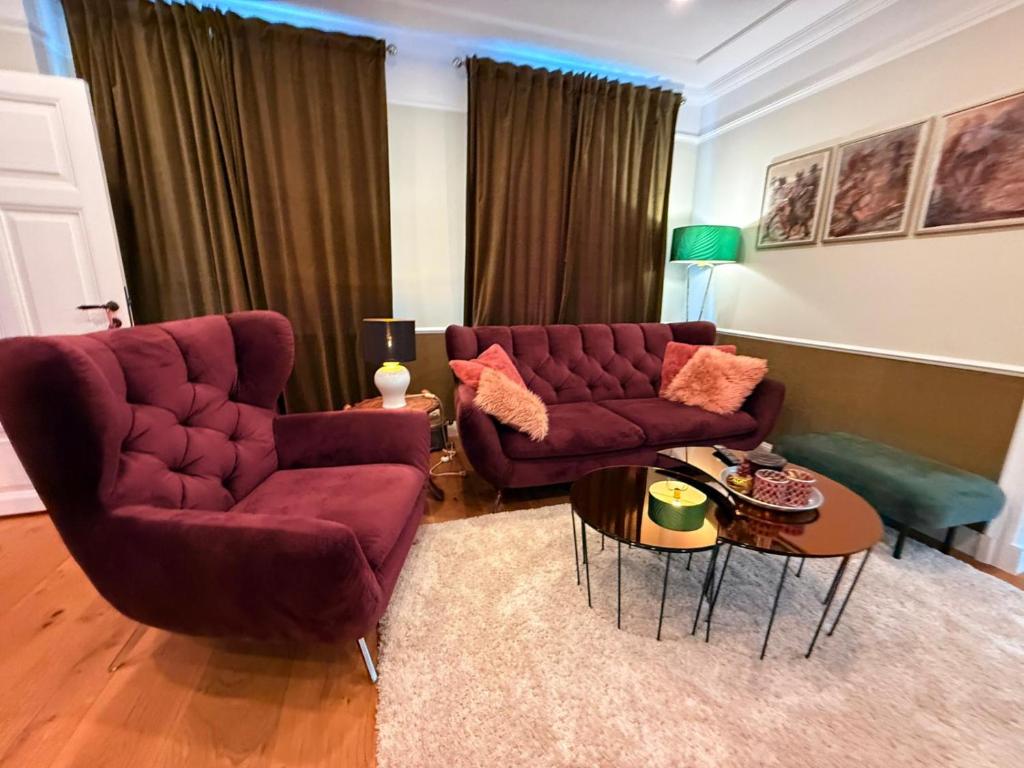 a living room with two couches and a table at Whisperwood Apartment in Colnrade