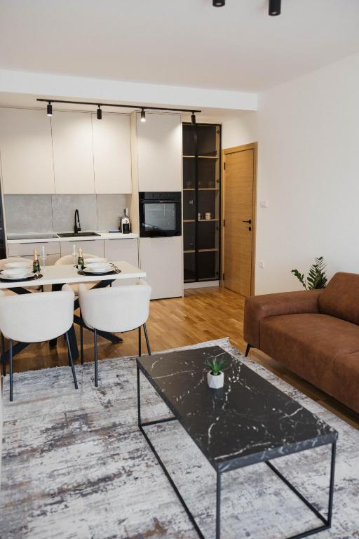 a living room with a couch and a table at Una Lux Apartment in Sombor