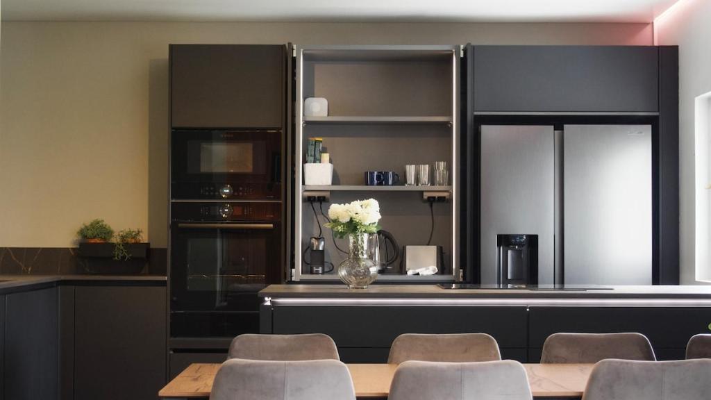 ヘルシンキにあるDesign home with sauna and spa in central Helsinkiのキッチン(テーブル、椅子、花瓶付)