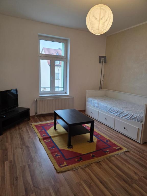 - un salon avec un lit et une table basse dans l'établissement Ferienwohnung Neukieritzsch, à Neukieritzsch