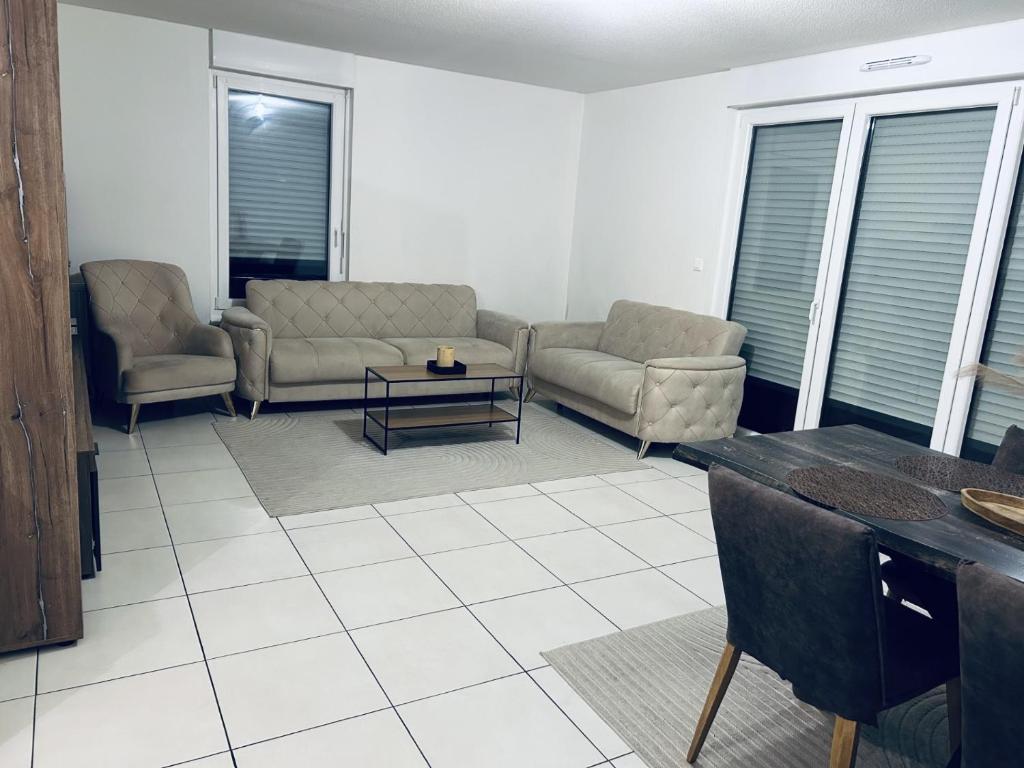 a living room with two couches and a table at Cocon family in Strasbourg