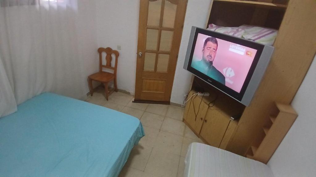 Cette petite chambre comprend une télévision et un lit. dans l'établissement Habitacion Privada 2 Personas Toledo, à Tolède