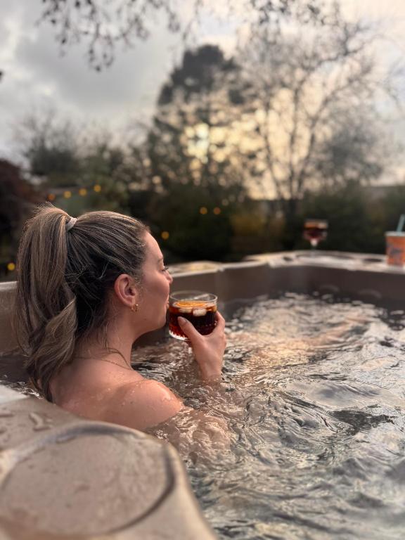 Eine Frau isst in einem Whirlpool ein Sandwich in der Unterkunft La Casa De Campo - Dog Friendly Cottage in Long Preston