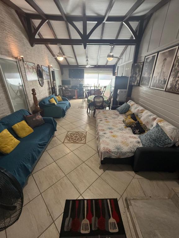 un salon avec canapés et une chambre avec dans l'établissement residence caramboles, à Fort-de-France