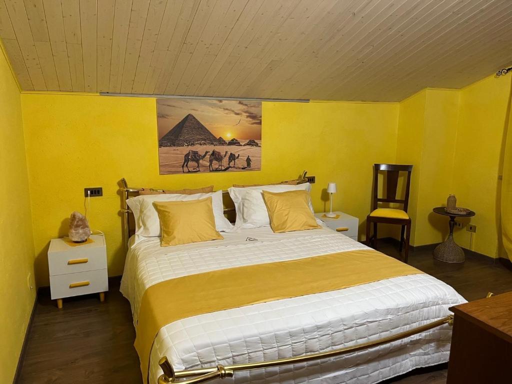 ein Schlafzimmer mit einem großen Bett mit gelben Wänden in der Unterkunft A Casa di Cheope in Bettolelle