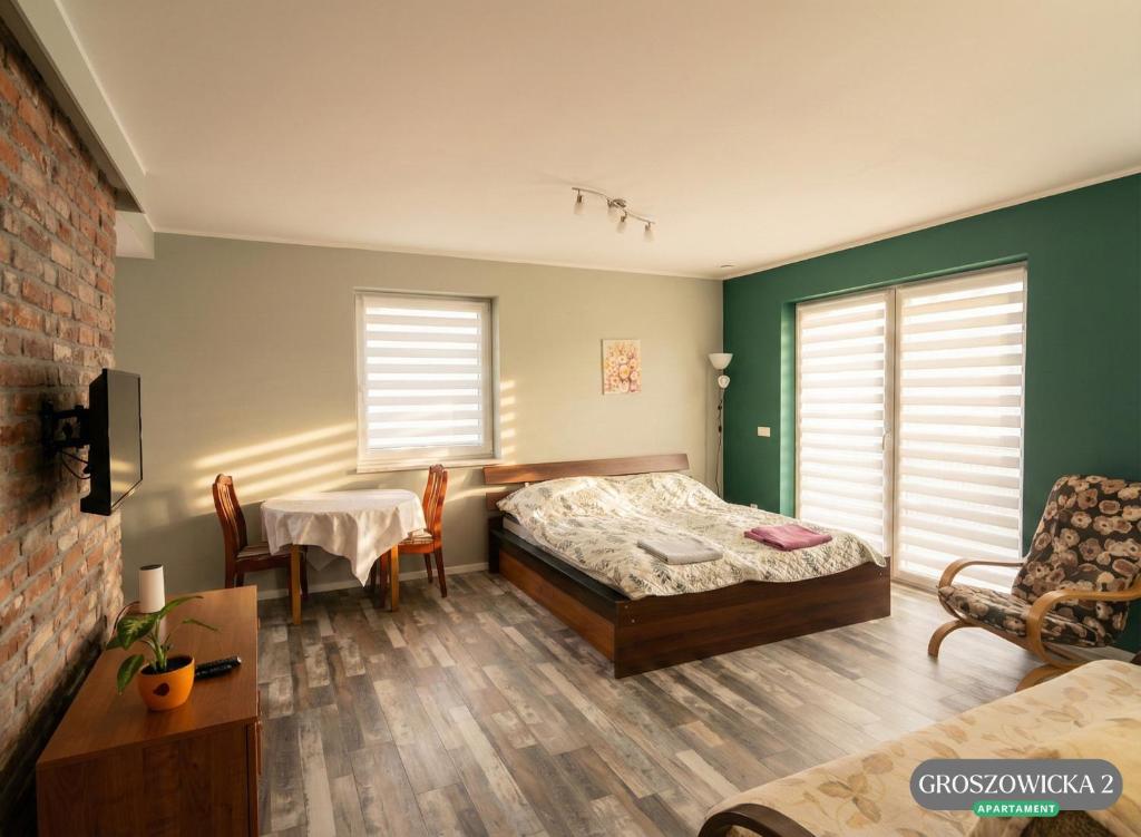 a bedroom with a bed and a table and chairs at Przytulne i ciepłe mieszkanie w spokojnej dzielnicy Opola in Opole