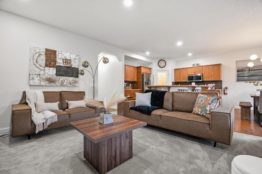 a living room with two couches and a table at The Copperleaf Luxury Retreat with Hot tub in Calgary